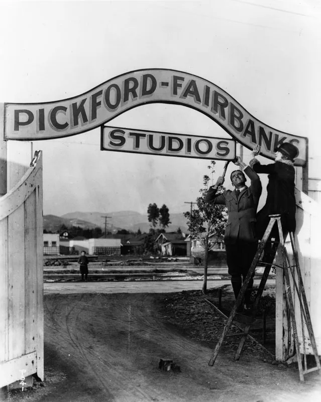Mary Pickford and Douglas Fairbanks hanging the sign of their studio in Hollywood in 1922.